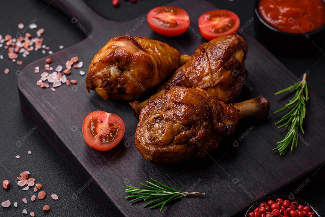 Deliciosas pernas de frango grelhado com especiarias e ervas em molho teriyaki sobre um fundo escuro de concreto