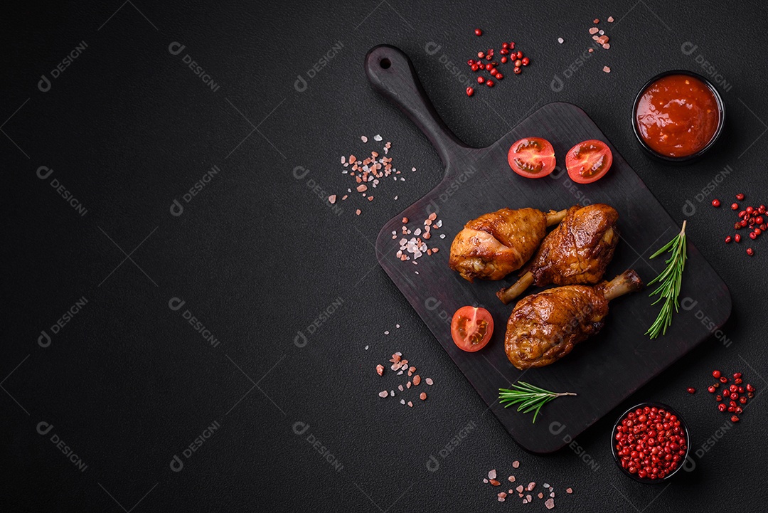 Deliciosas pernas de frango grelhado com especiarias e ervas em molho teriyaki sobre um fundo escuro de concreto