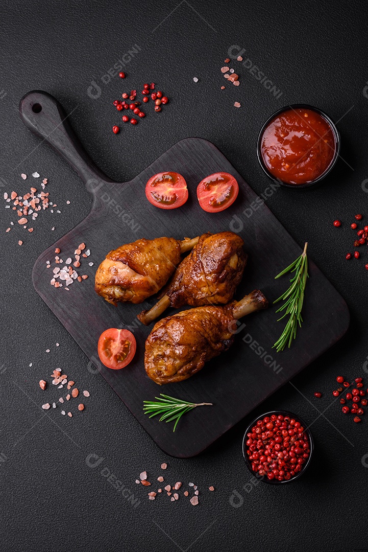 Deliciosas pernas de frango grelhado com especiarias e ervas em molho teriyaki sobre um fundo escuro de concreto