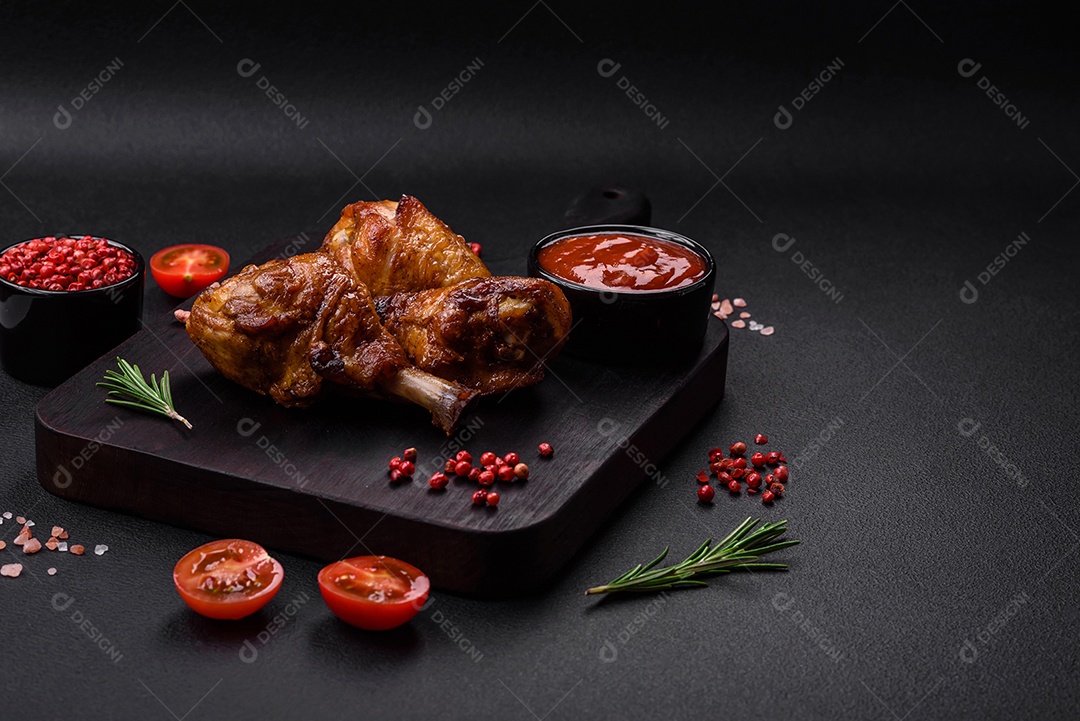 Deliciosas pernas de frango grelhado com especiarias e ervas em molho teriyaki sobre um fundo escuro de concreto