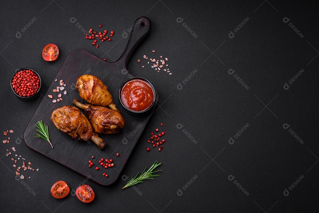 Deliciosas pernas de frango grelhado com especiarias e ervas em molho teriyaki sobre um fundo escuro de concreto