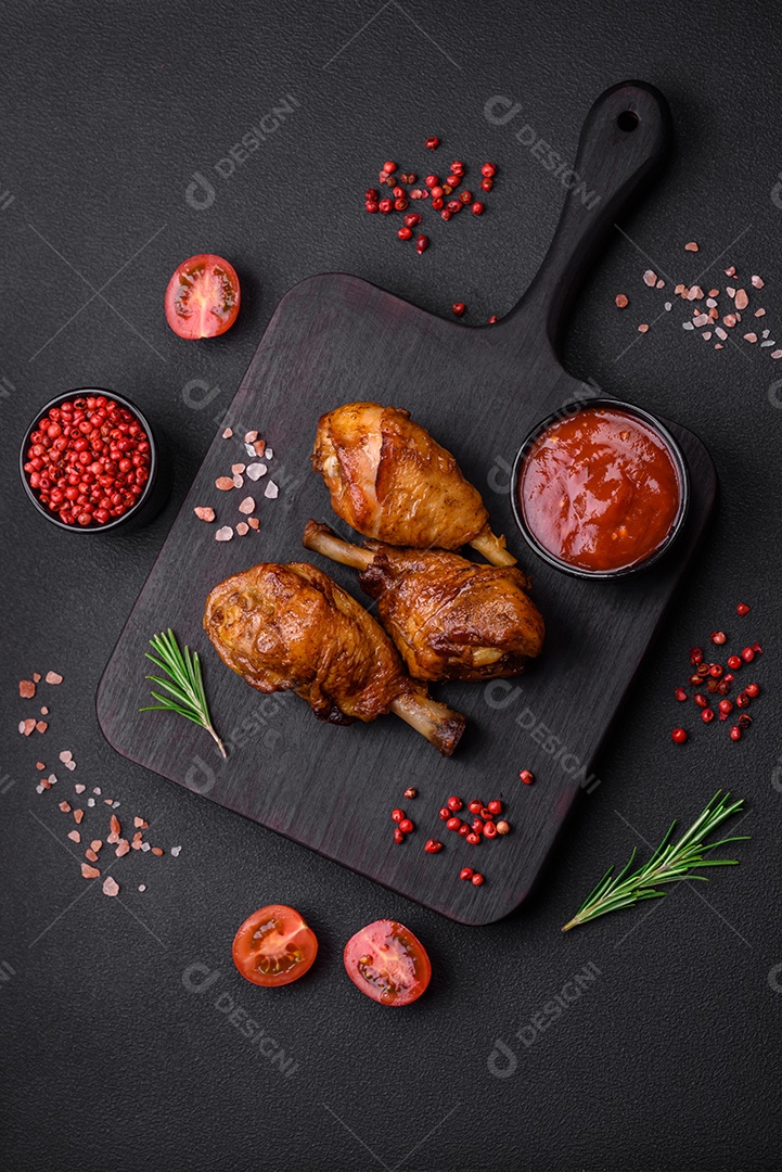 Deliciosas pernas de frango grelhado com especiarias e ervas em molho teriyaki sobre um fundo escuro de concreto