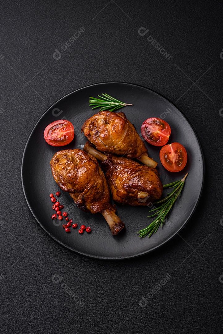 Deliciosas pernas de frango grelhado com especiarias e ervas em molho teriyaki sobre um fundo escuro de concreto