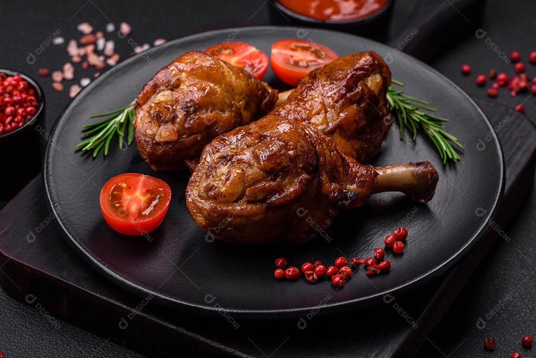 Deliciosas pernas de frango grelhado com especiarias e ervas em molho teriyaki sobre um fundo escuro de concreto