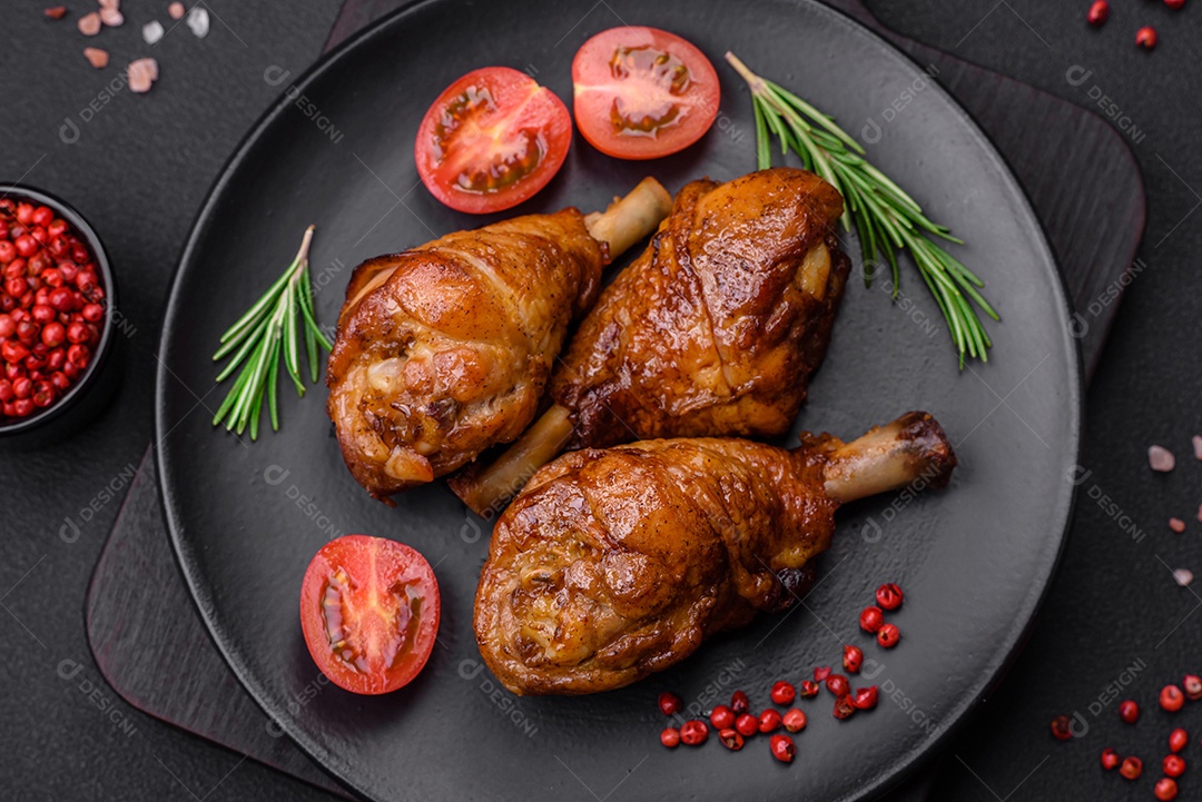 Deliciosas pernas de frango grelhado com especiarias e ervas em molho teriyaki sobre um fundo escuro de concreto