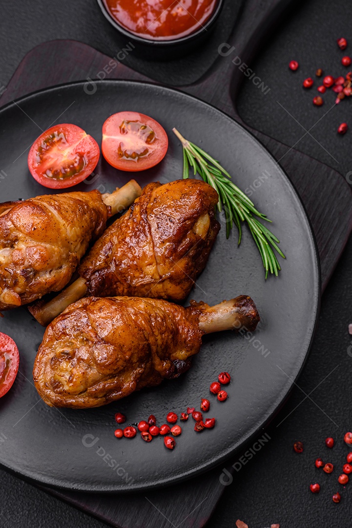 Deliciosas pernas de frango grelhado com especiarias e ervas em molho teriyaki sobre um fundo escuro de concreto
