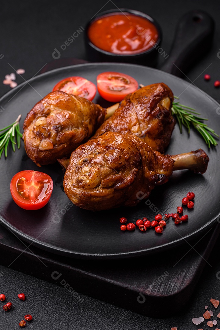 Deliciosas pernas de frango grelhado com especiarias e ervas em molho teriyaki sobre um fundo escuro de concreto