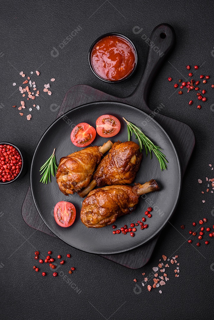 Deliciosas pernas de frango grelhado com especiarias e ervas em molho teriyaki sobre um fundo escuro de concreto