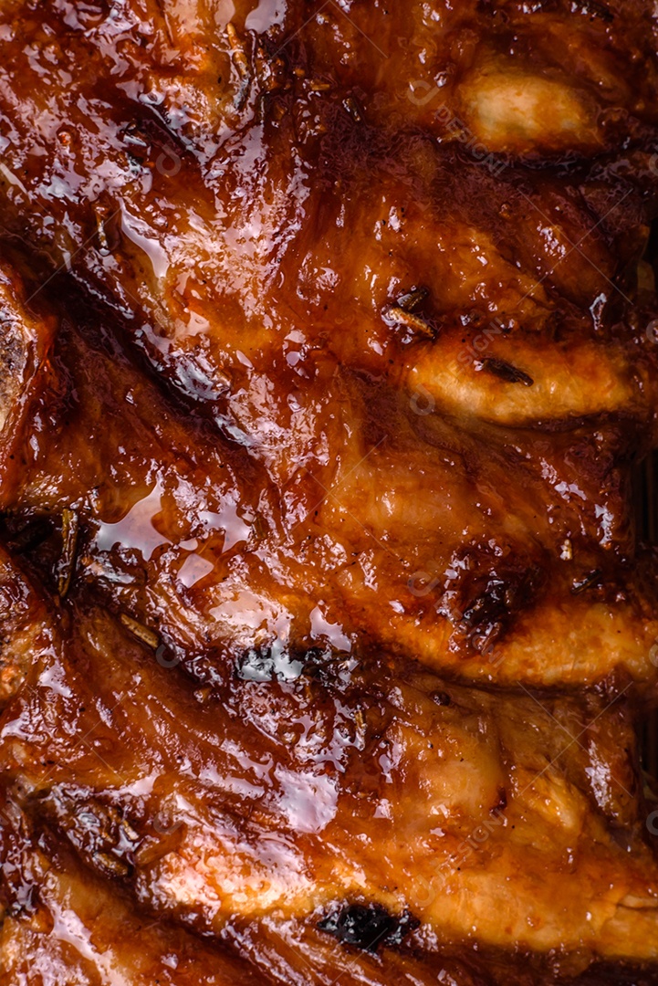 Deliciosas pernas de frango grelhado com especiarias e ervas em molho teriyaki sobre um fundo escuro de concreto