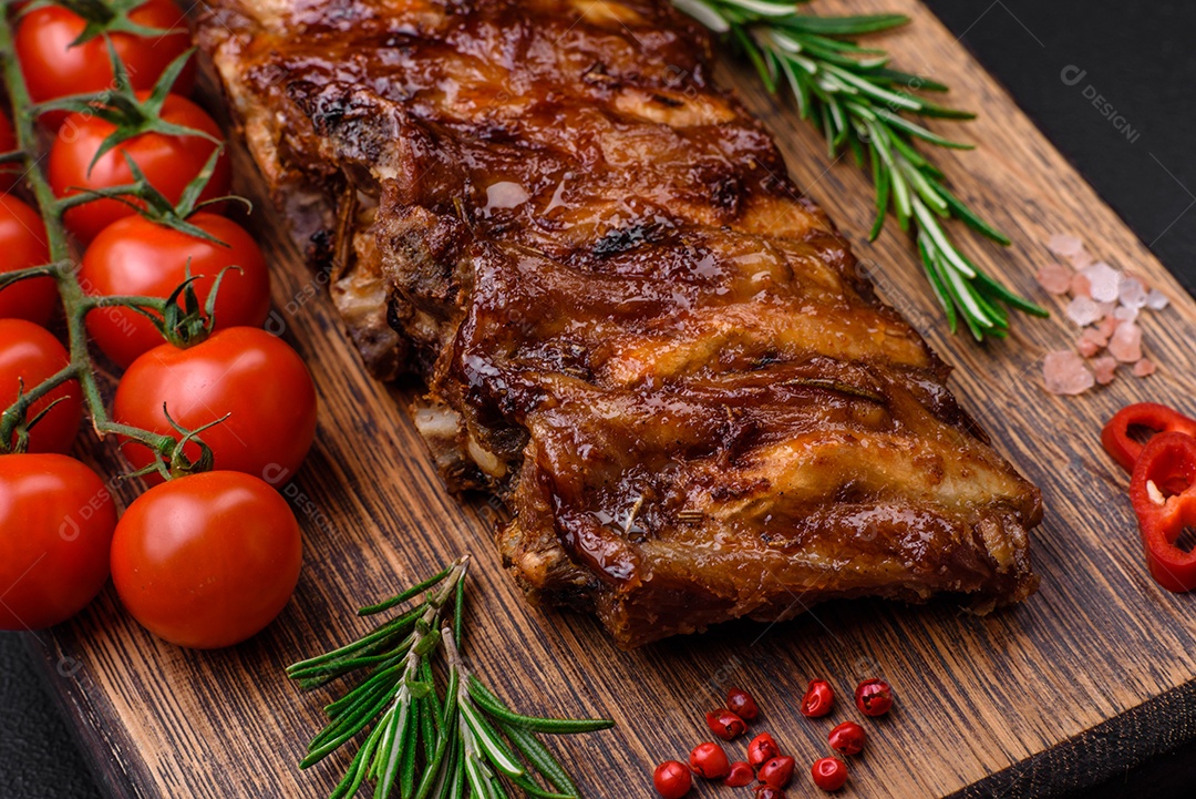 Deliciosas pernas de frango grelhado com especiarias e ervas em molho teriyaki sobre um fundo escuro de concreto