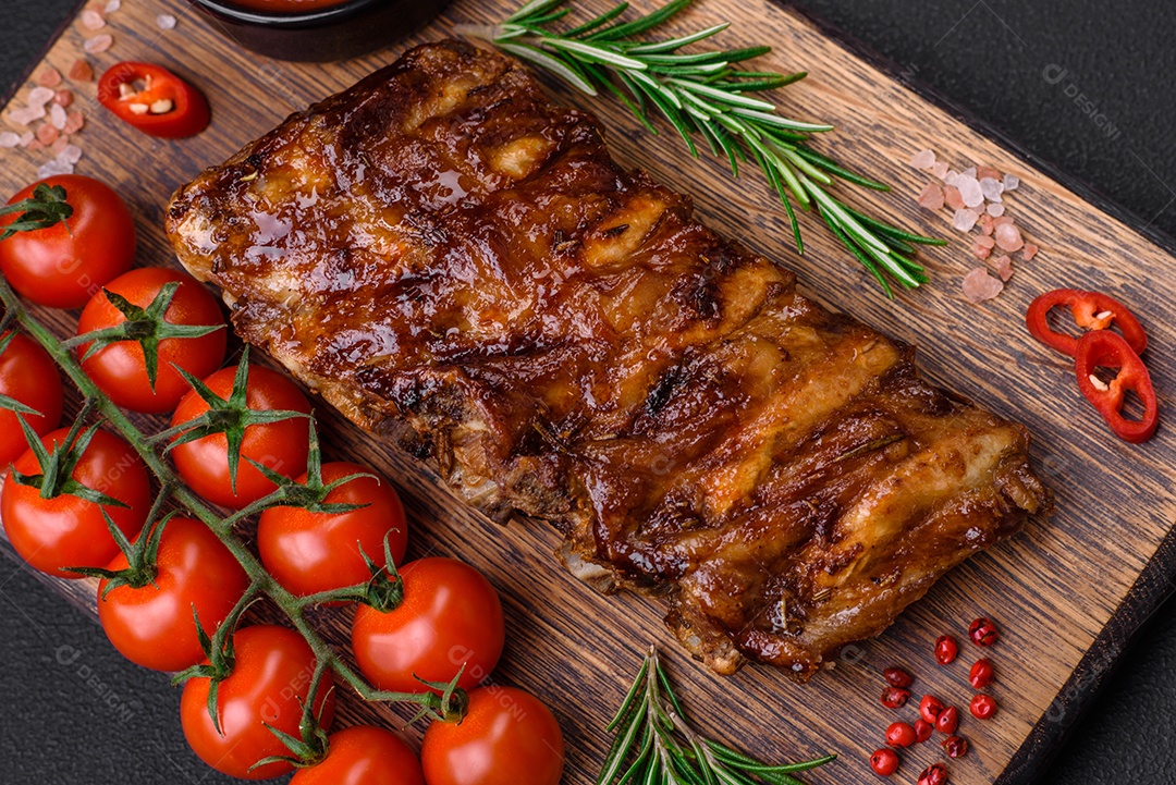 Deliciosas pernas de frango grelhado com especiarias e ervas em molho teriyaki sobre um fundo escuro de concreto