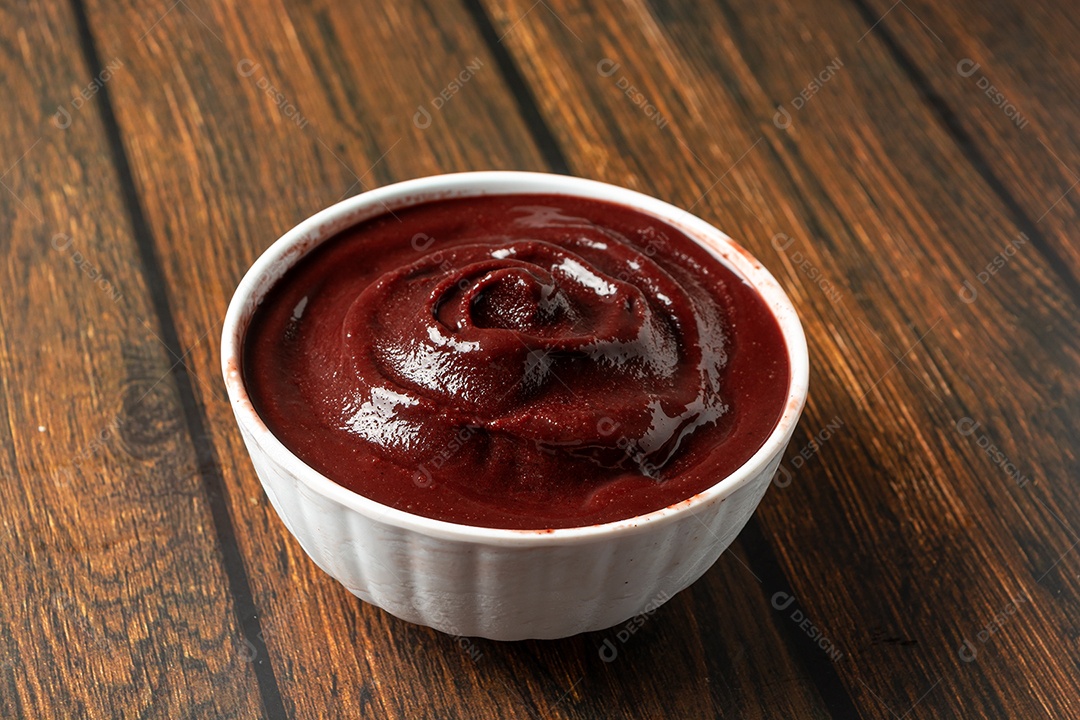 Tigela com açaí e colher de pau sobre a mesa