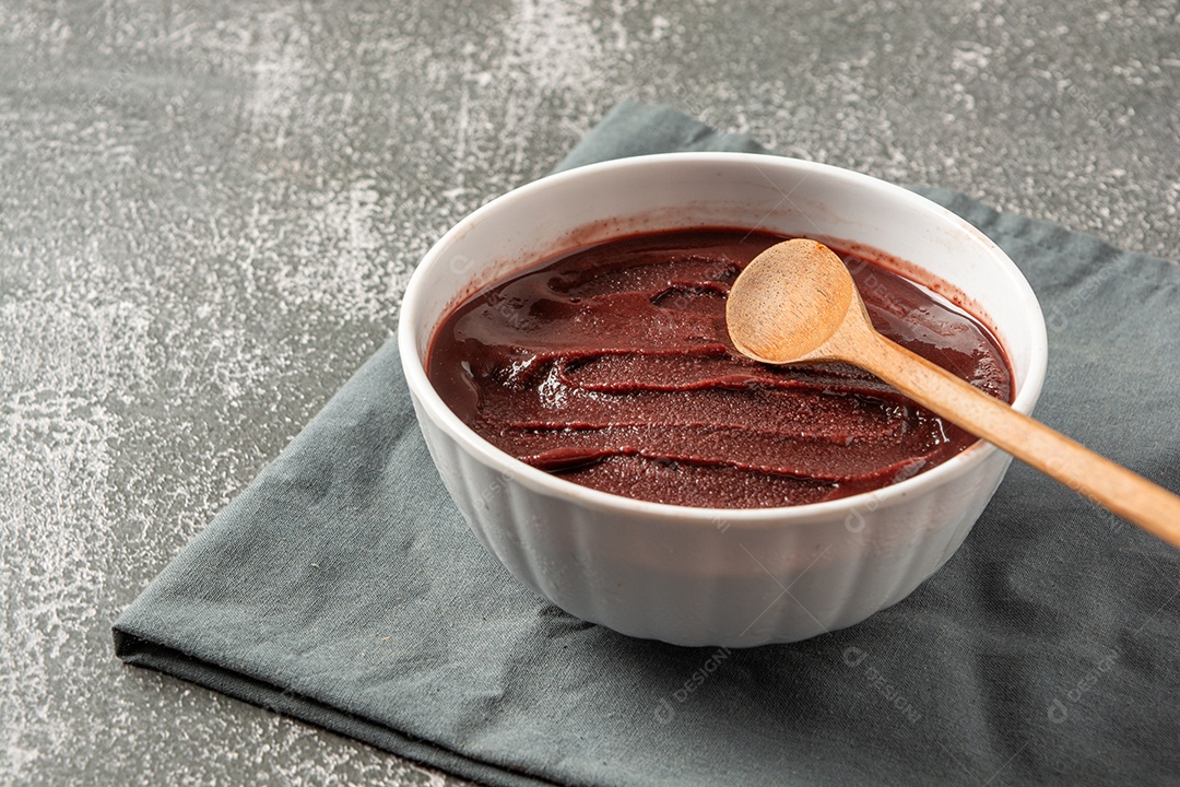 Tigela com açaí e colher de pau sobre a mesa