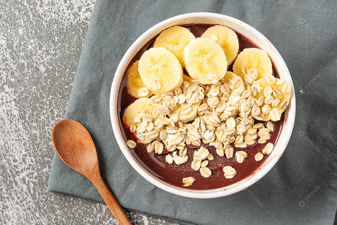 Açaí natural com rodelas de banana em uma tigela sobre a mesa de madeira. vista do topo