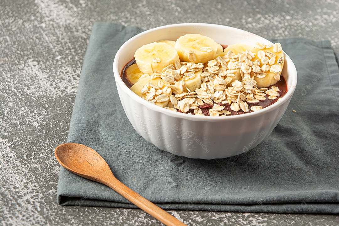 Açaí natural com rodelas de banana em uma tigela sobre a mesa de madeira. vista do topo