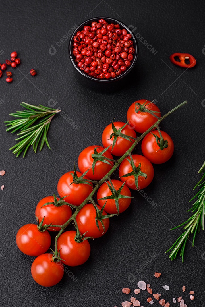 Deliciosos tomates cereja frescos em um galho em um fundo escuro de concreto. Cozinha vegetariana
