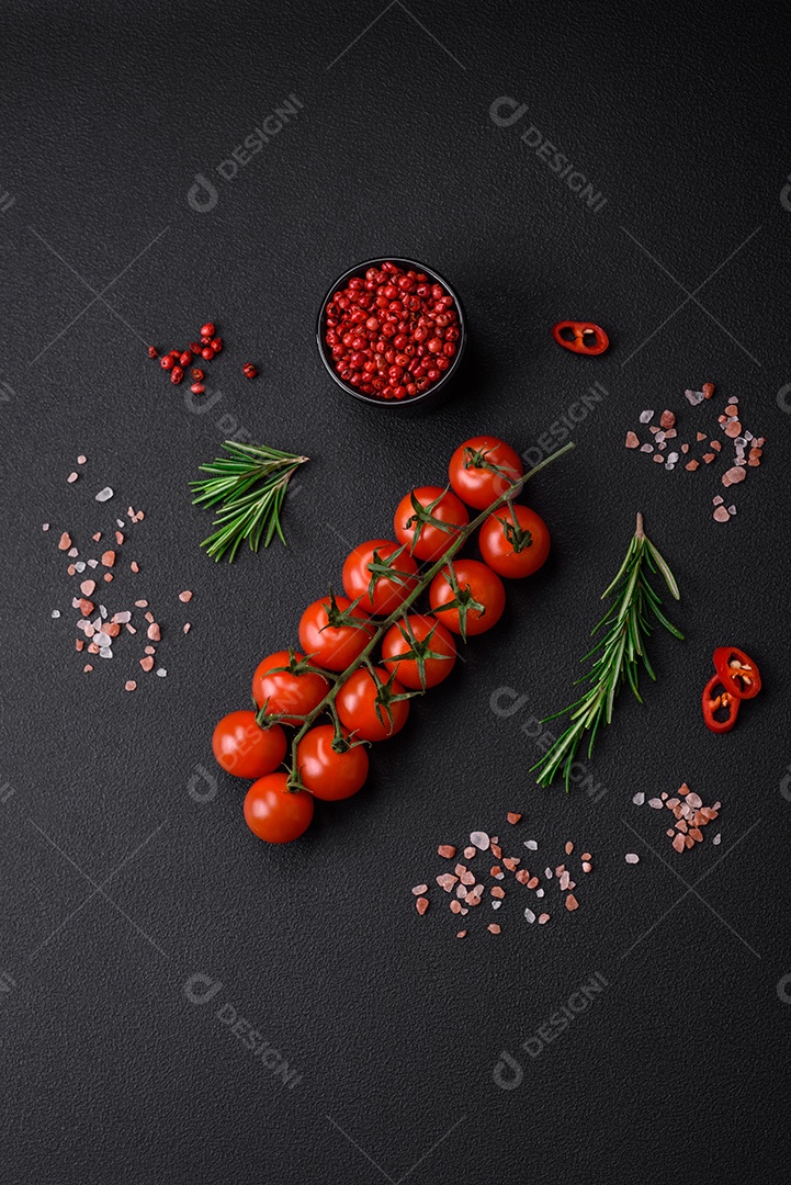 Deliciosos tomates cereja frescos em um galho em um fundo escuro de concreto. Cozinha vegetariana