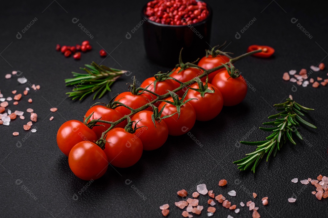 Deliciosos tomates cereja frescos em um galho em um fundo escuro de concreto. Cozinha vegetariana