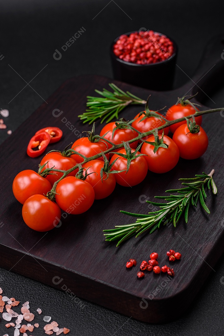 Deliciosos tomates cereja frescos em um galho em um fundo escuro de concreto. Cozinha vegetariana