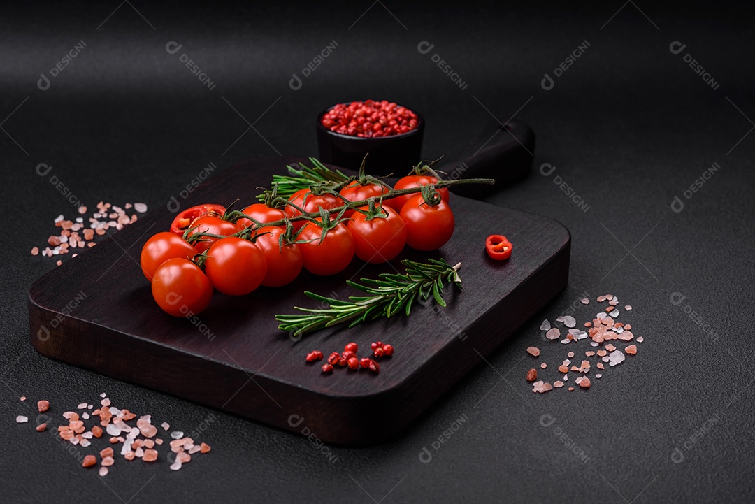 Deliciosos tomates cereja frescos em um galho em um fundo escuro de concreto. Cozinha vegetariana