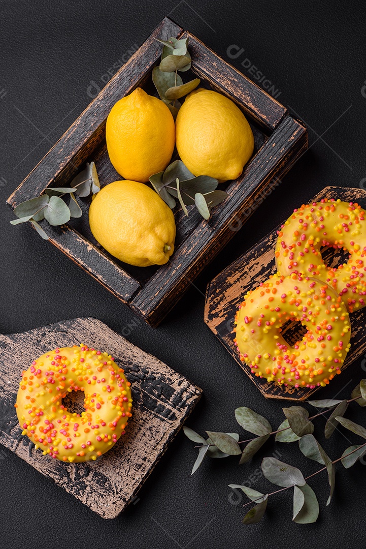 Deliciosos donuts frescos em esmalte amarelo com recheio de sabor de limão em fundo de concreto texturizado