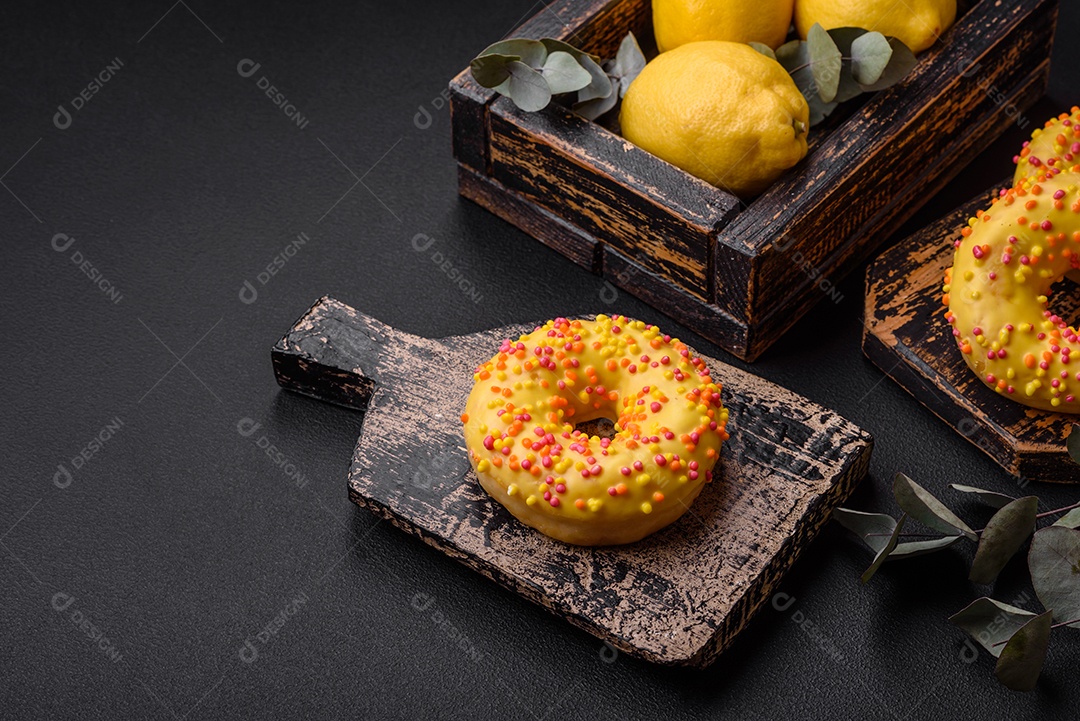 Deliciosos donuts frescos em esmalte amarelo com recheio de sabor de limão em fundo de concreto texturizado