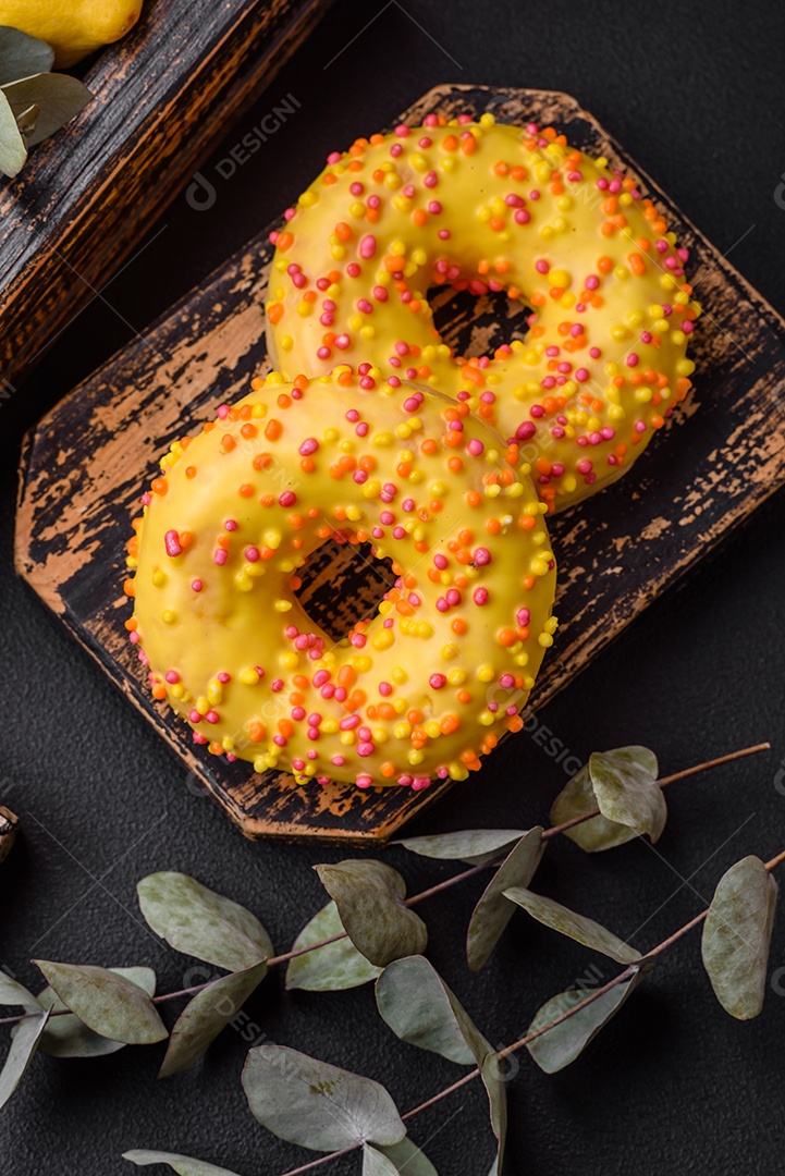 Deliciosos donuts frescos em esmalte amarelo com recheio de sabor de limão em fundo de concreto texturizado