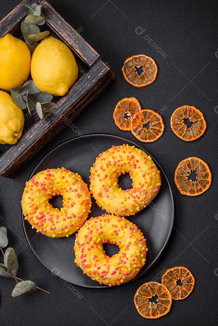 Deliciosos donuts frescos em esmalte amarelo com recheio de sabor de limão em fundo de concreto texturizado