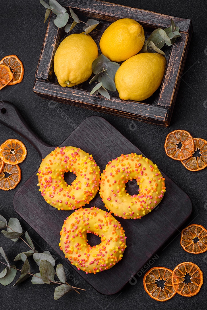 Deliciosos donuts frescos em esmalte amarelo com recheio de sabor de limão em fundo de concreto texturizado
