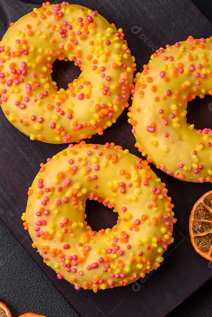 Deliciosos donuts frescos em esmalte amarelo com recheio de sabor de limão em fundo de concreto texturizado