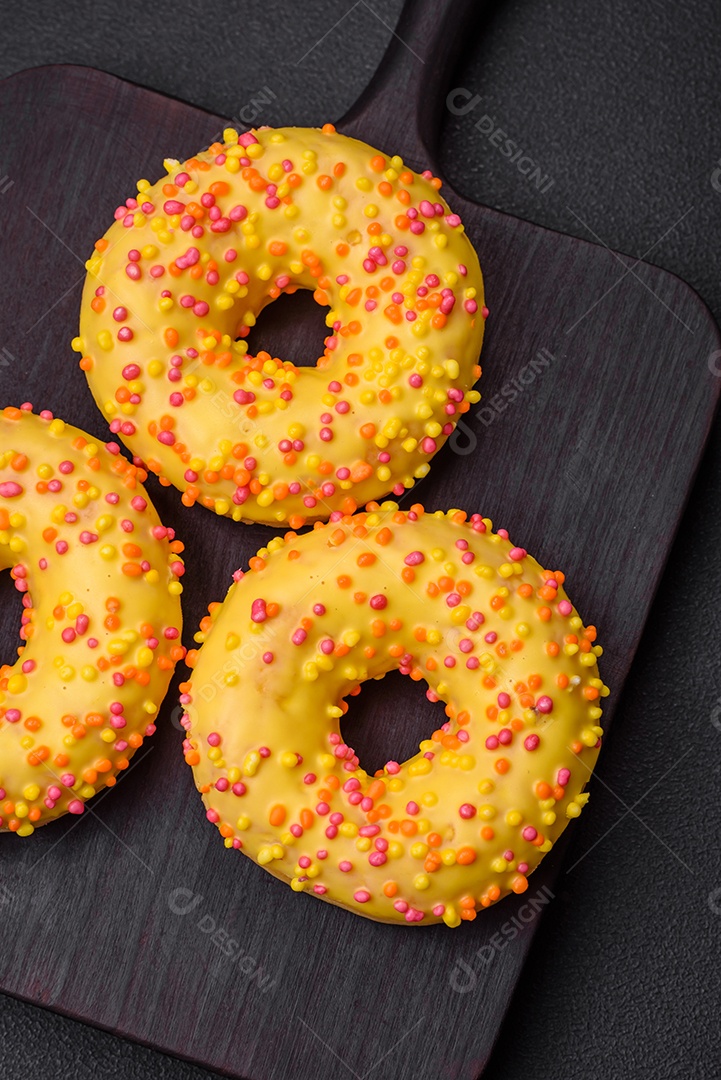 Deliciosos donuts frescos em esmalte amarelo com recheio de sabor de limão em fundo de concreto texturizado