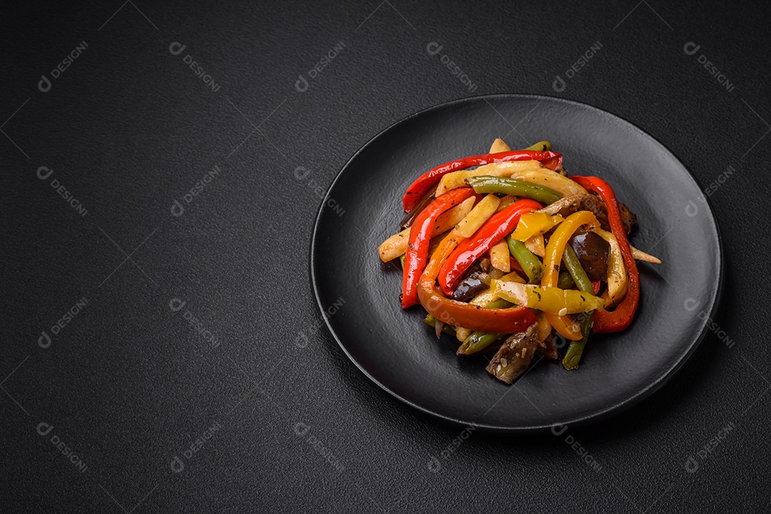 Legumes deliciosos pimentões cozidos no vapor, feijão de espargos e batatas fatiadas com molho de soja sobre um fundo escuro de concreto