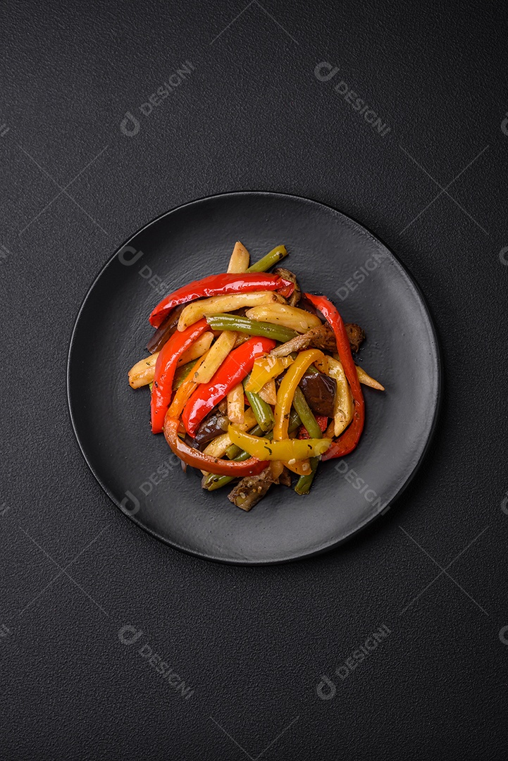 Legumes deliciosos pimentões cozidos no vapor, feijão de espargos e batatas fatiadas com molho de soja sobre um fundo escuro de concreto