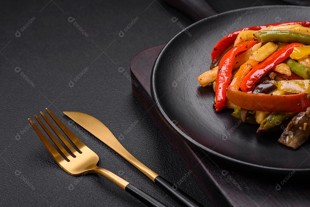 Legumes deliciosos pimentões cozidos no vapor, feijão de espargos e batatas fatiadas com molho de soja sobre um fundo escuro de concreto