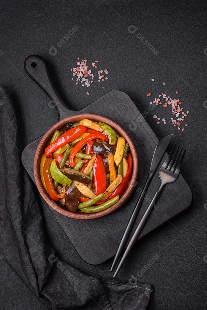 Legumes deliciosos pimentões cozidos no vapor, feijão de espargos e batatas fatiadas com molho de soja sobre um fundo escuro de concreto