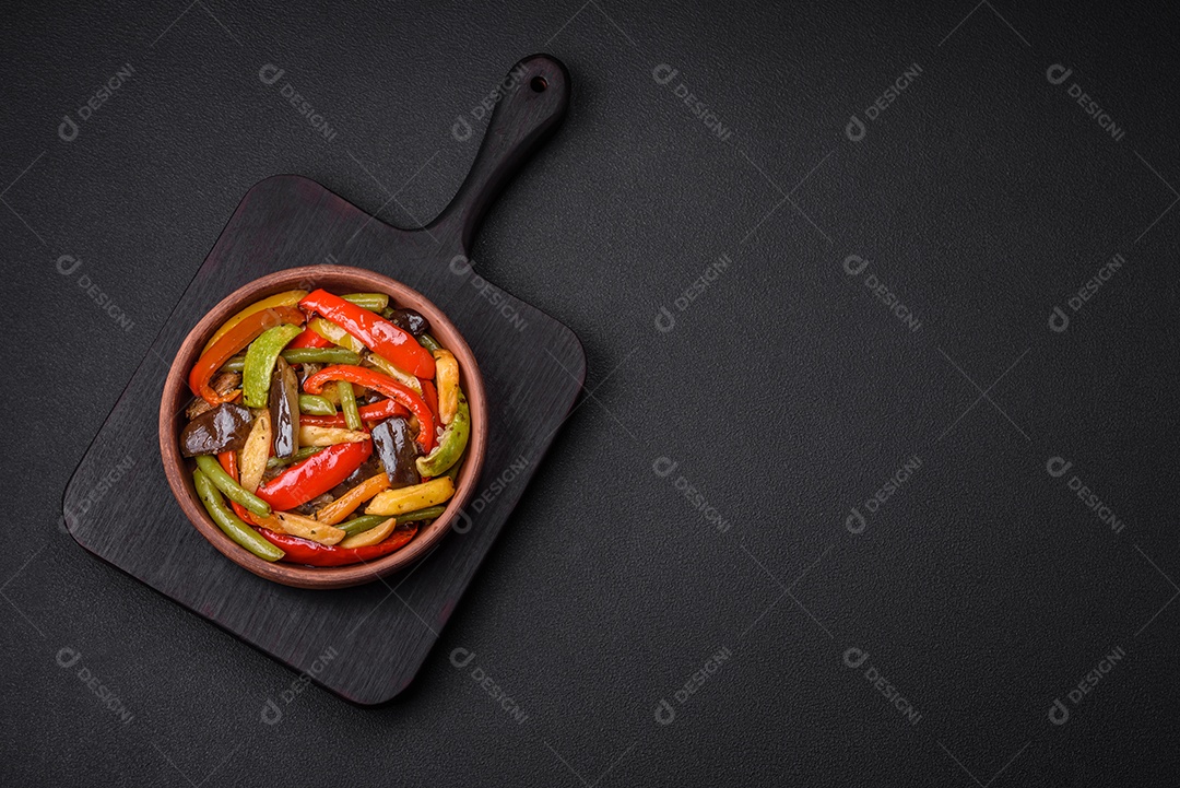 Legumes deliciosos pimentões cozidos no vapor, feijão de espargos e batatas fatiadas com molho de soja sobre um fundo escuro de concreto