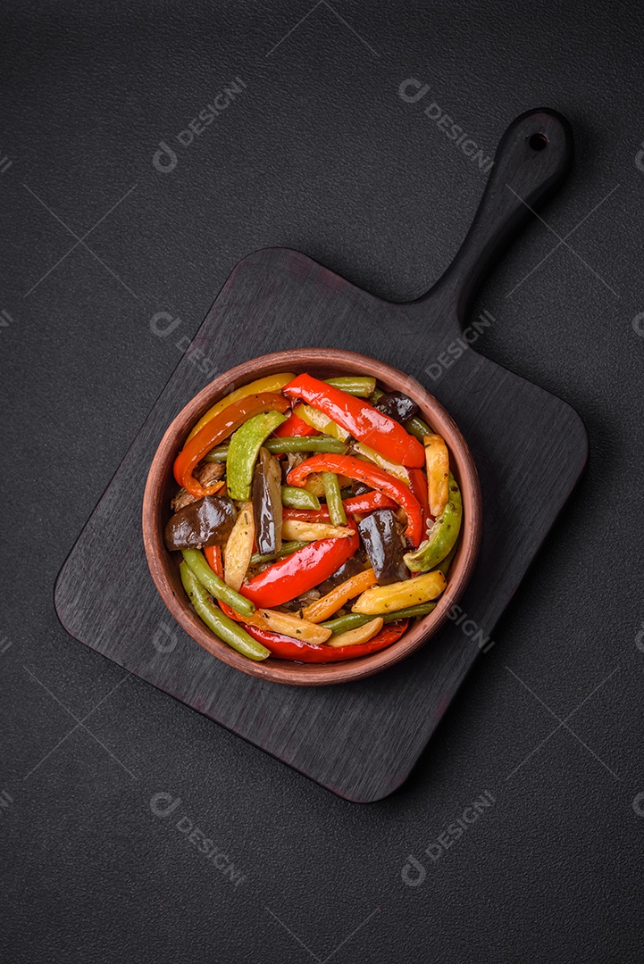 Legumes deliciosos pimentões cozidos no vapor, feijão de espargos e batatas fatiadas com molho de soja sobre um fundo escuro de concreto