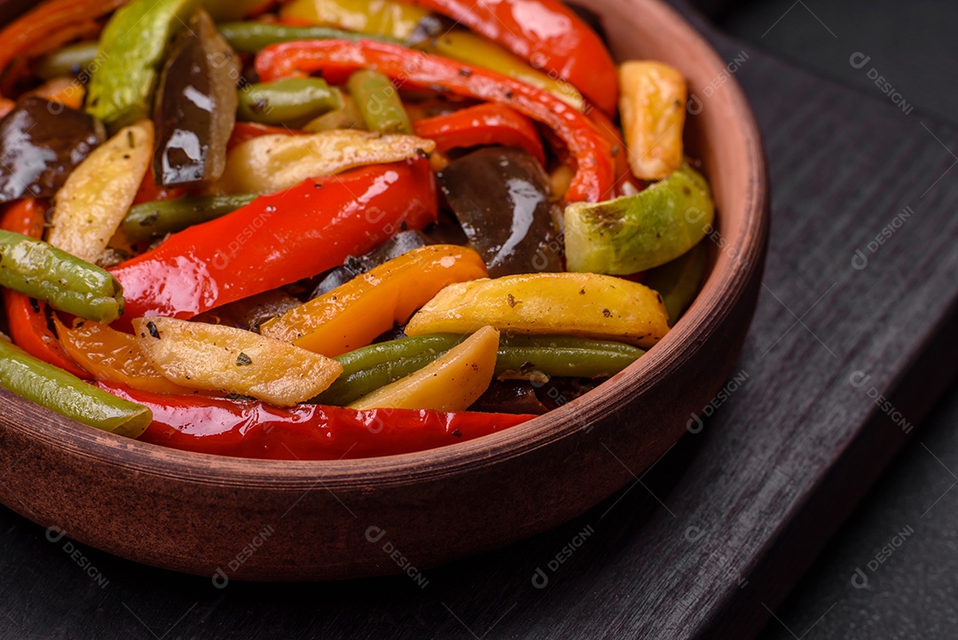 Legumes deliciosos pimentões cozidos no vapor, feijão de espargos e batatas fatiadas com molho de soja sobre um fundo escuro de concreto