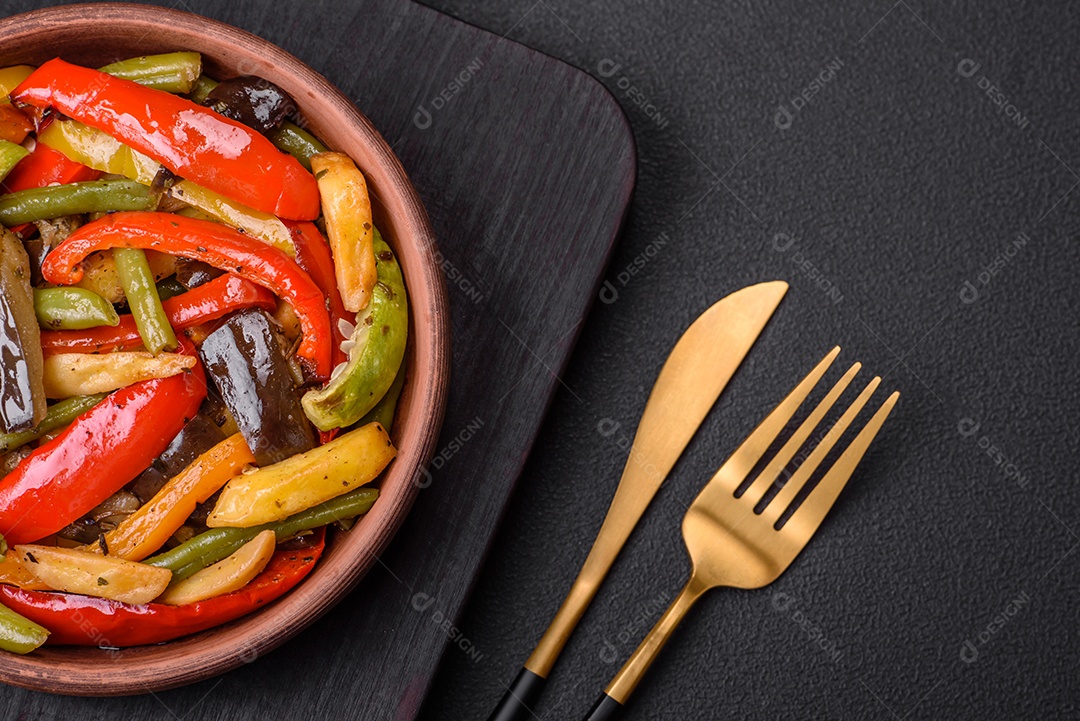 Legumes deliciosos pimentões cozidos no vapor, feijão de espargos e batatas fatiadas com molho de soja sobre um fundo escuro de concreto