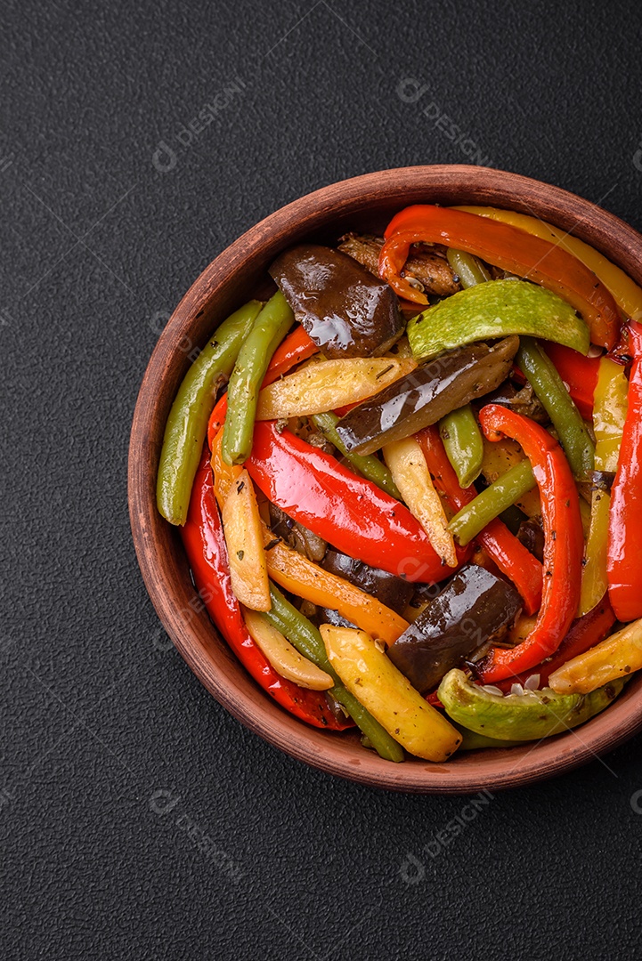 Legumes deliciosos pimentões cozidos no vapor, feijão de espargos e batatas fatiadas com molho de soja sobre um fundo escuro de concreto