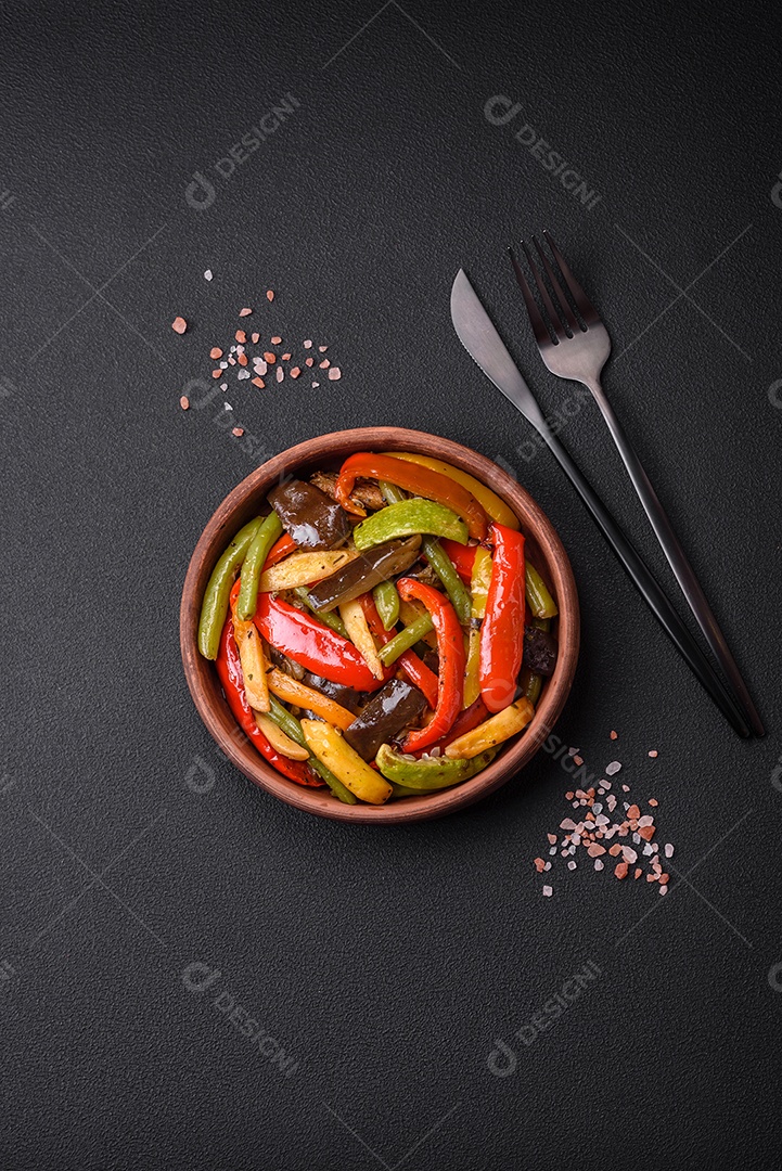 Legumes deliciosos pimentões cozidos no vapor, feijão de espargos e batatas fatiadas com molho de soja sobre um fundo escuro de concreto