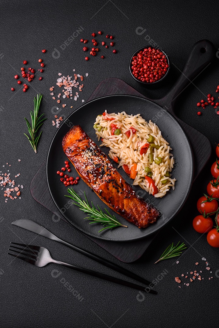 Delicioso salmão vermelho grelhado com molho, sementes de gergelim, especiarias e ervas sobre fundo escuro de concreto