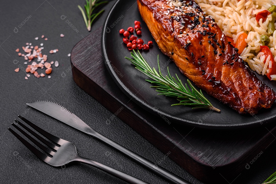Delicioso salmão vermelho grelhado com molho e sementes de gergelim com arroz, legumes, especiarias e ervas