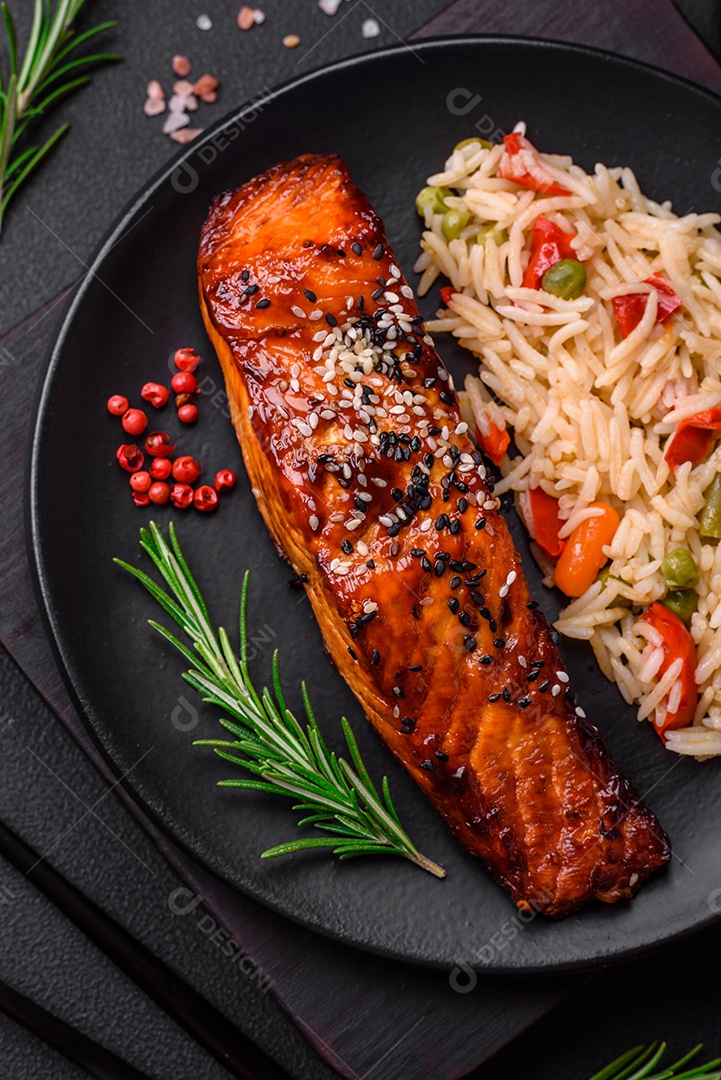 Delicioso salmão vermelho grelhado com molho e sementes de gergelim com arroz, legumes, especiarias e ervas