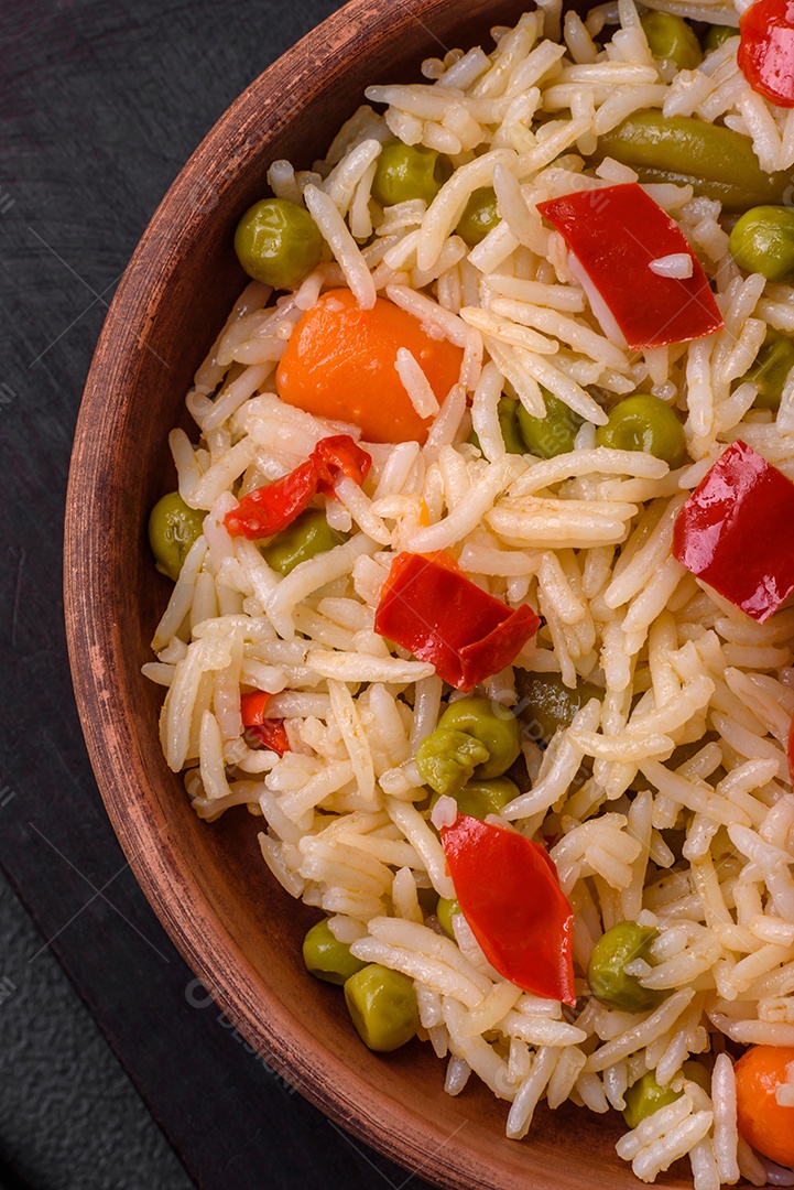 Delicioso arroz cozido com legumes, pimentões, cenouras, ervilhas e feijões de espargos com especiarias e ervas