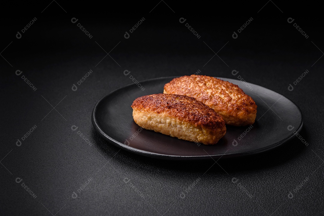 Deliciosas costeletas fritas ou almôndegas de peixe picado com especiarias e ervas sobre um fundo escuro de concreto