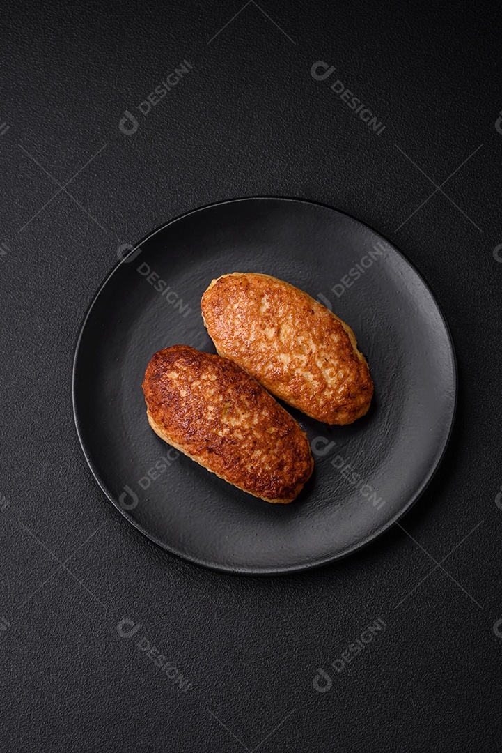 Deliciosas costeletas fritas ou almôndegas de peixe picado com especiarias e ervas sobre um fundo escuro de concreto