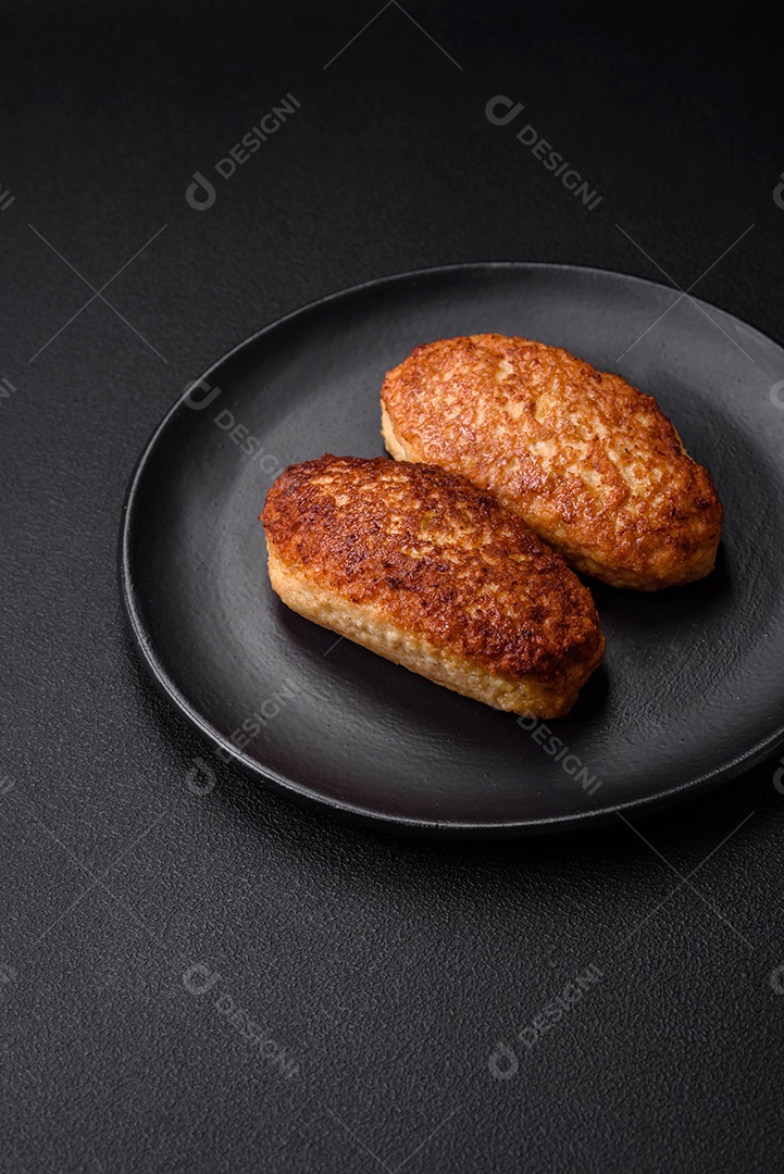 Deliciosas costeletas fritas ou almôndegas de peixe picado com especiarias e ervas sobre um fundo escuro de concreto
