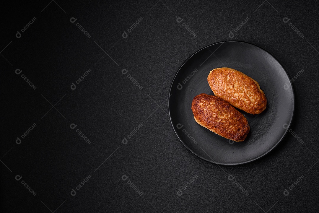 Deliciosas costeletas fritas ou almôndegas de peixe picado com especiarias e ervas sobre um fundo escuro de concreto