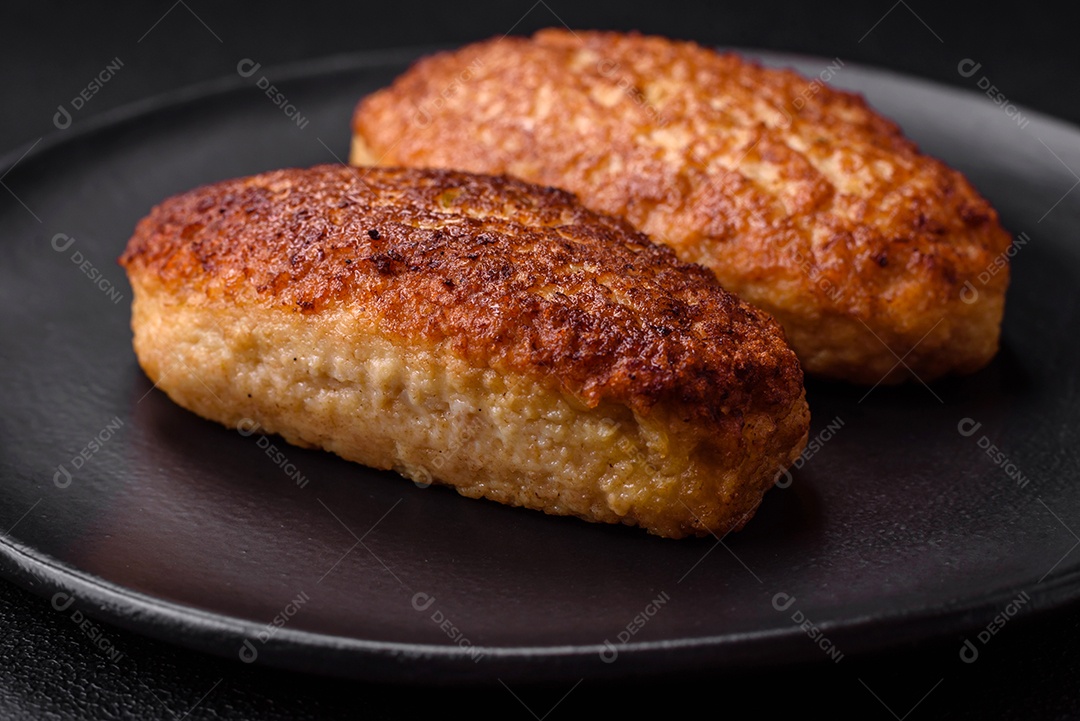 Deliciosas costeletas fritas ou almôndegas de peixe picado com especiarias e ervas sobre um fundo escuro de concreto